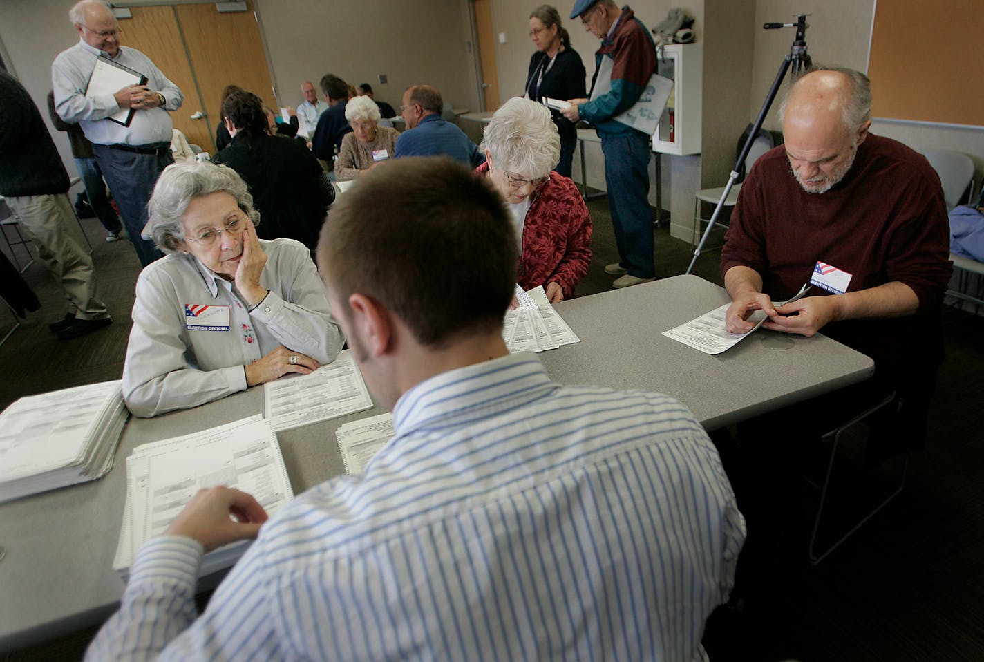 Election officials — from left, Jeannette Gudgel, Katherine Halverson and Roy Diekmann — watched and counted ballots as Luke Leadbetter sorted through them at the Ramsey County Elections Bureau on Monday. The county is auditing ballots cast last Tuesday in selected precincts by hand-counting them.