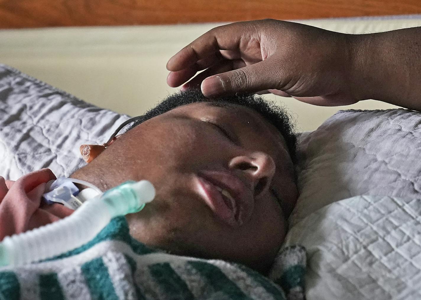 Jonathan Harris, 31, who also functions as a PCA for his brother Josh, stroked his brother's head as Josh awoke from a nap Thursday at the family home in Eagan.