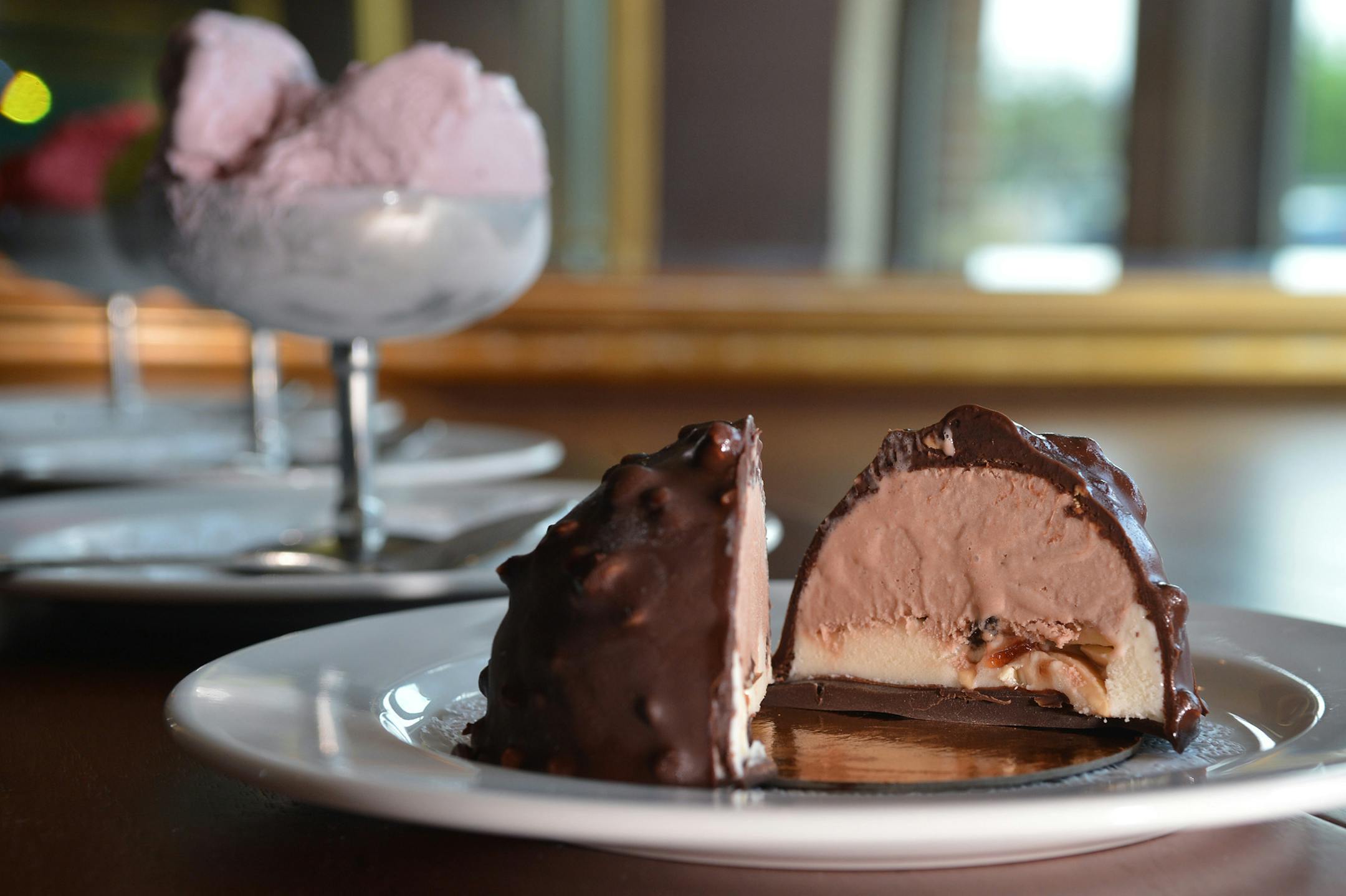 Cosseta's tartuco, a traditional Italian dessert of chocolate gelato with rum flavoring filled with amarena cherries, candied almonds and vanilla gelato covered with chocolate and peanuts.
