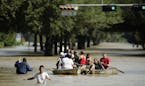 People evacuate a neighborhood inundated after water was released from nearby Addicks Reservoir when it reached capacity due to Tropical Storm Harvey 