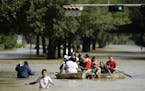 People evacuate a neighborhood inundated after water was released from nearby Addicks Reservoir when it reached capacity due to Tropical Storm Harvey 