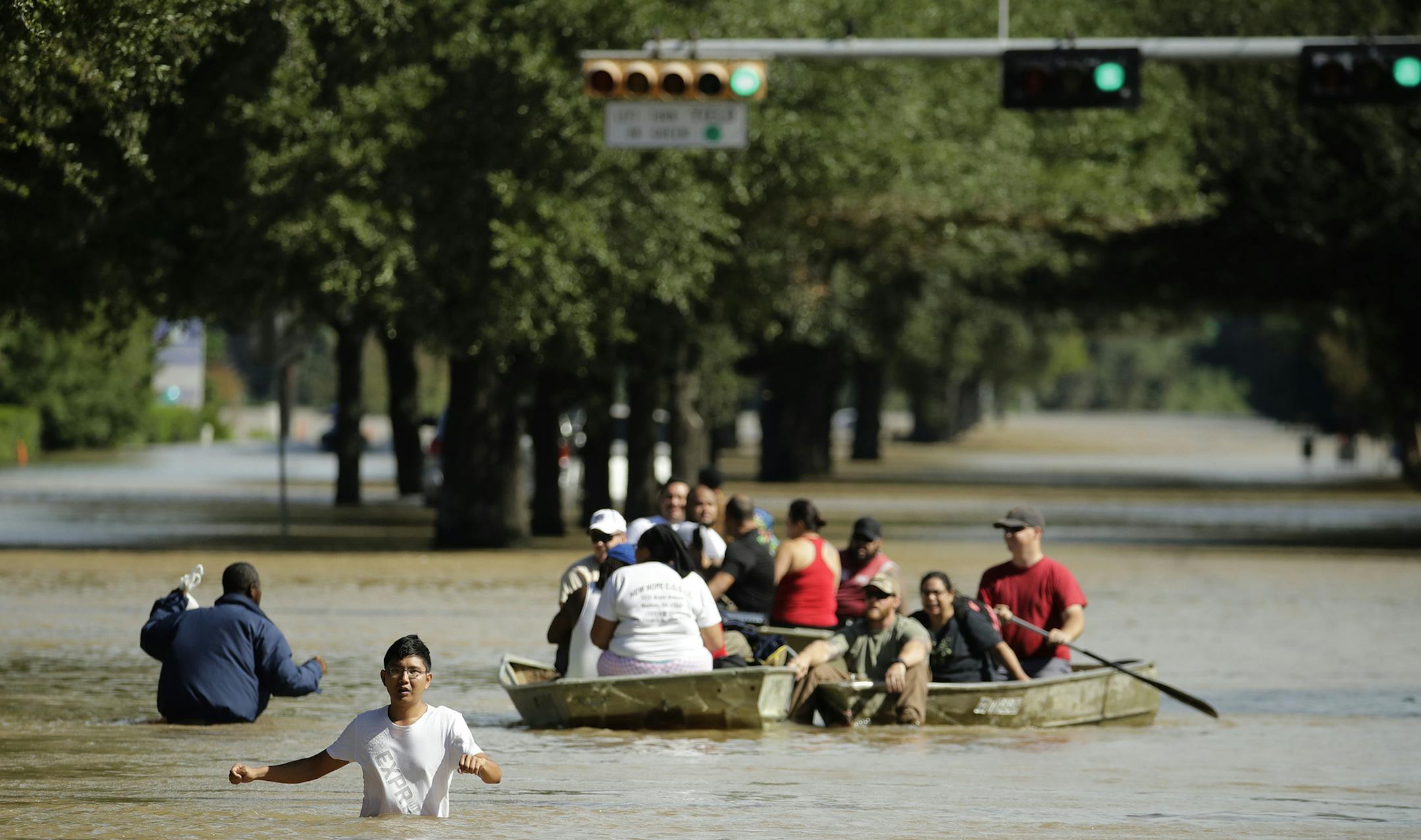 People evacuate a neighborhood inundated after water was released from nearby Addicks Reservoir when it reached capacity due to Tropical Storm Harvey on Wednesday, Aug. 30, 2017, in Houston. (AP Photo/Charlie Riedel) ORG XMIT: MIN2017083013001849