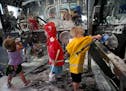 Croix Xavier,2.5, far right, of Richmond, Wisconsin, gets a kick out of the the car wash. It is part of the first exhibit, called "Forces at Play," in