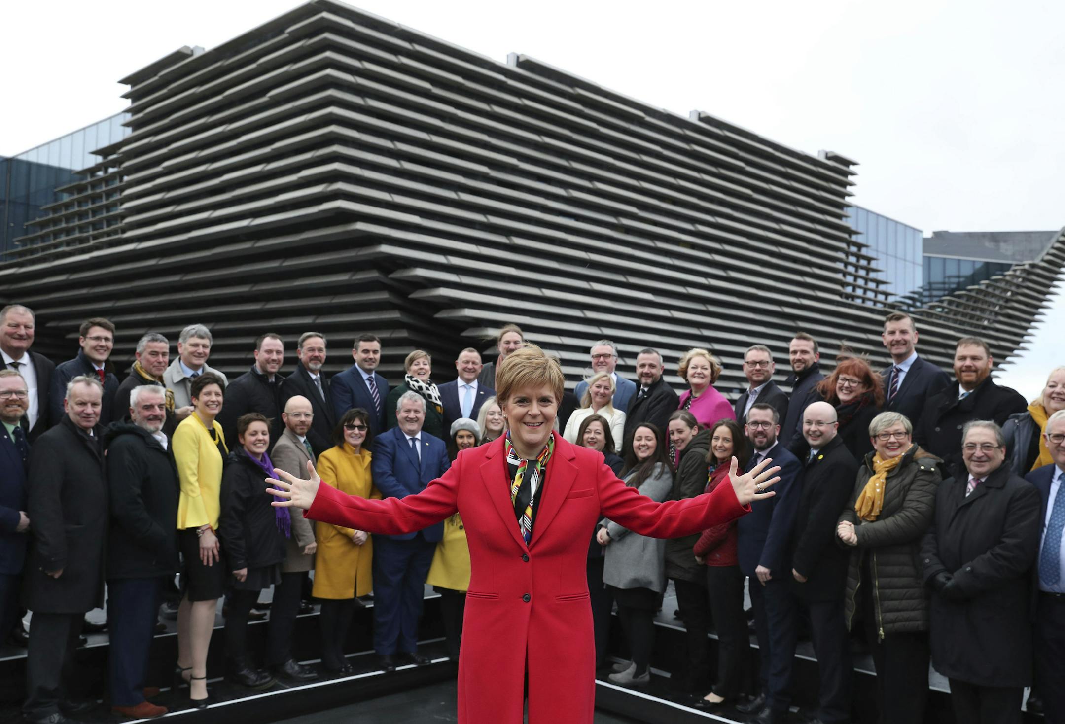 Scottish First Minister Nicola Sturgeon poses with newly elected MPs of Scottish National Party (SNP) during a photo opportunity as they gather outside the V&A Museum in Dundee, Scotland, Saturday Dec. 14, 2019. Sturgeon delivered a landslide election victory for the SNP, with a campaign focused on demands for a second referendum on Scottish independence, but Prime MinisterBoris Johnson has flatly rebuffed the idea of another vote. (Andrew Milligan/PA via AP)