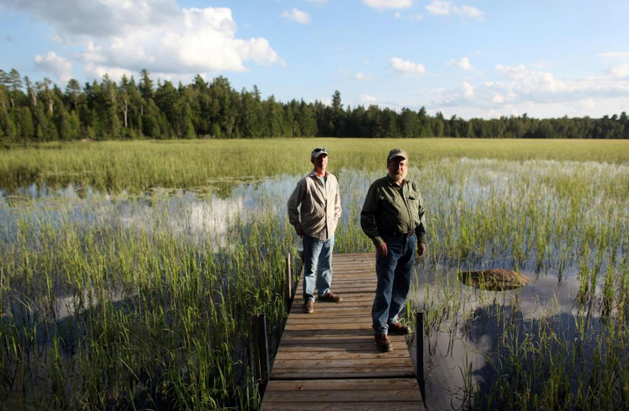 Ron Brodigan and his son Steve Brodigan posed on a dock in Sand Lake, which is full of wild rice. They are among those who have raised concerns about copper mining in northern Minnesota because of its threat to private property rights and its potential environmental impacts, including on wild rice.