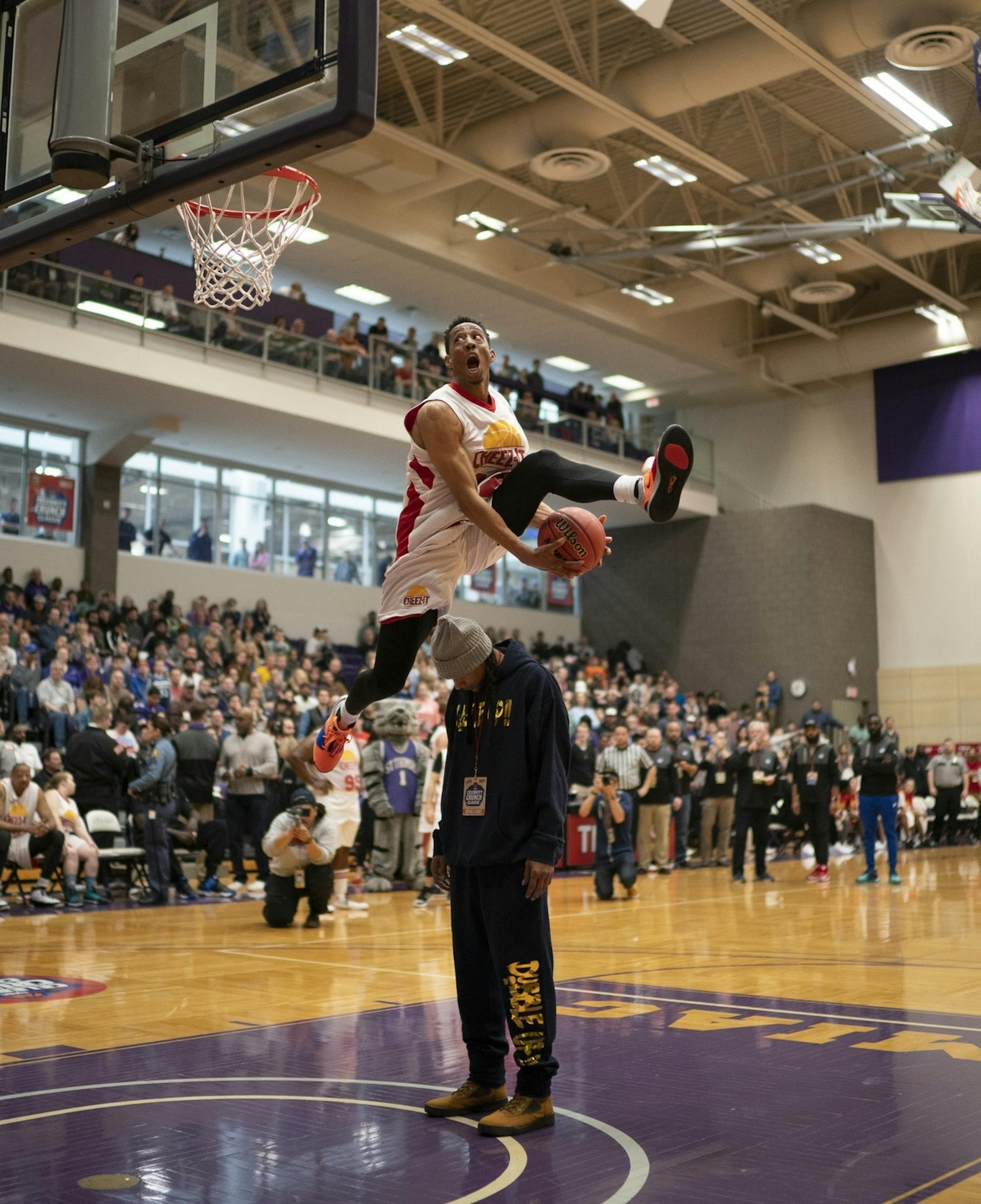 Jonathan Clark of Team Cheez-It and the Flight Brothers, soared over a volunteer during the dunking contest, which he won.