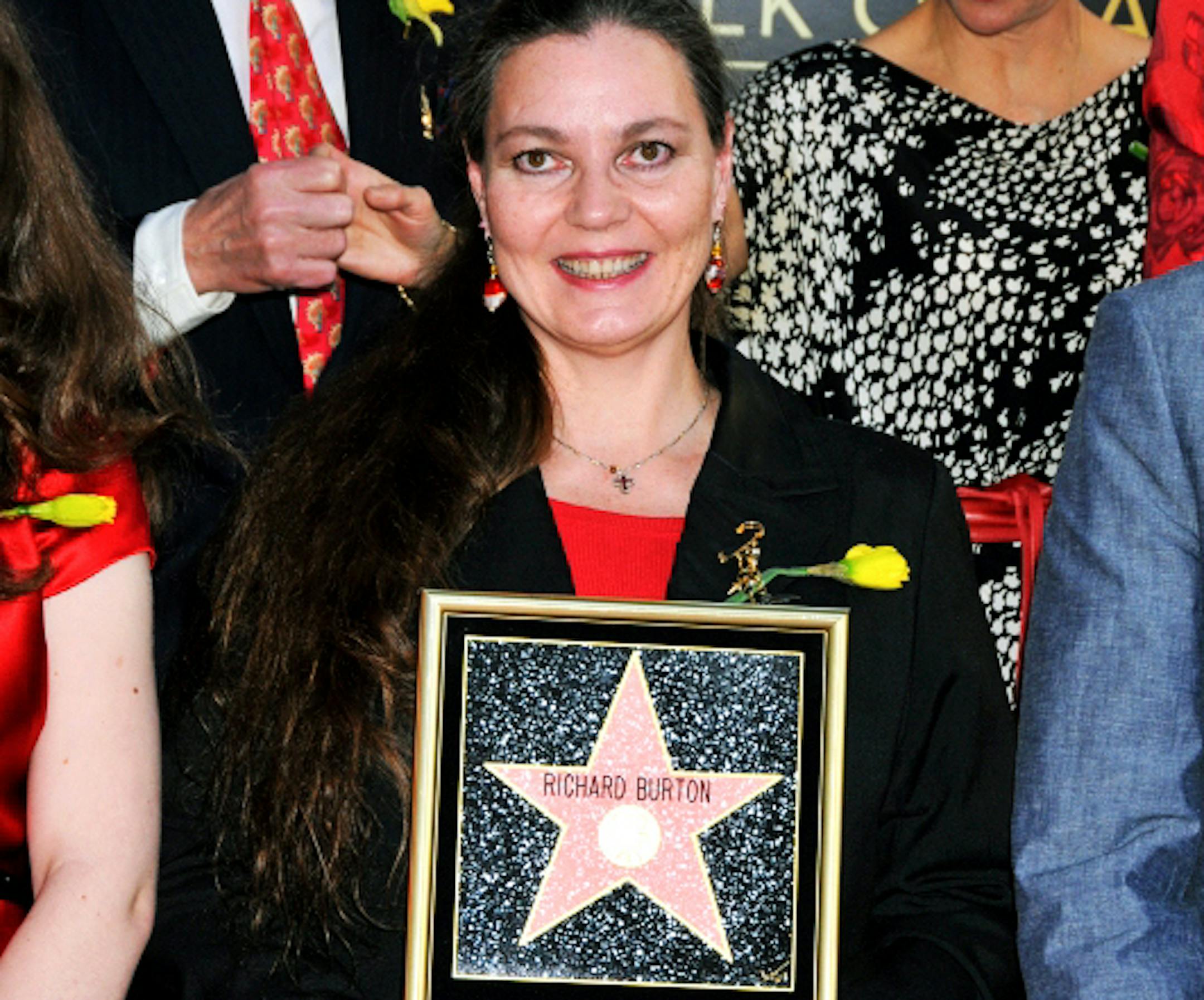 Maria Burton McKeown, daughter of the late actor Richard Burton and actress Elizabeth Taylor, poses with her father's star plaque at the Hollywood Walk of Fame Star Ceremony for Burton in Los Angeles on Friday, March 1, 2013. Burton's new star is placed next to the star of Elizabeth Taylor. The posthumous honor coincides with the celebration of the 50th anniversary of the feature film "Cleopatra" available on Blu-ray for the first time on May 21. (AP Photo/Hollywood Chamber of Commerce, Bob Free