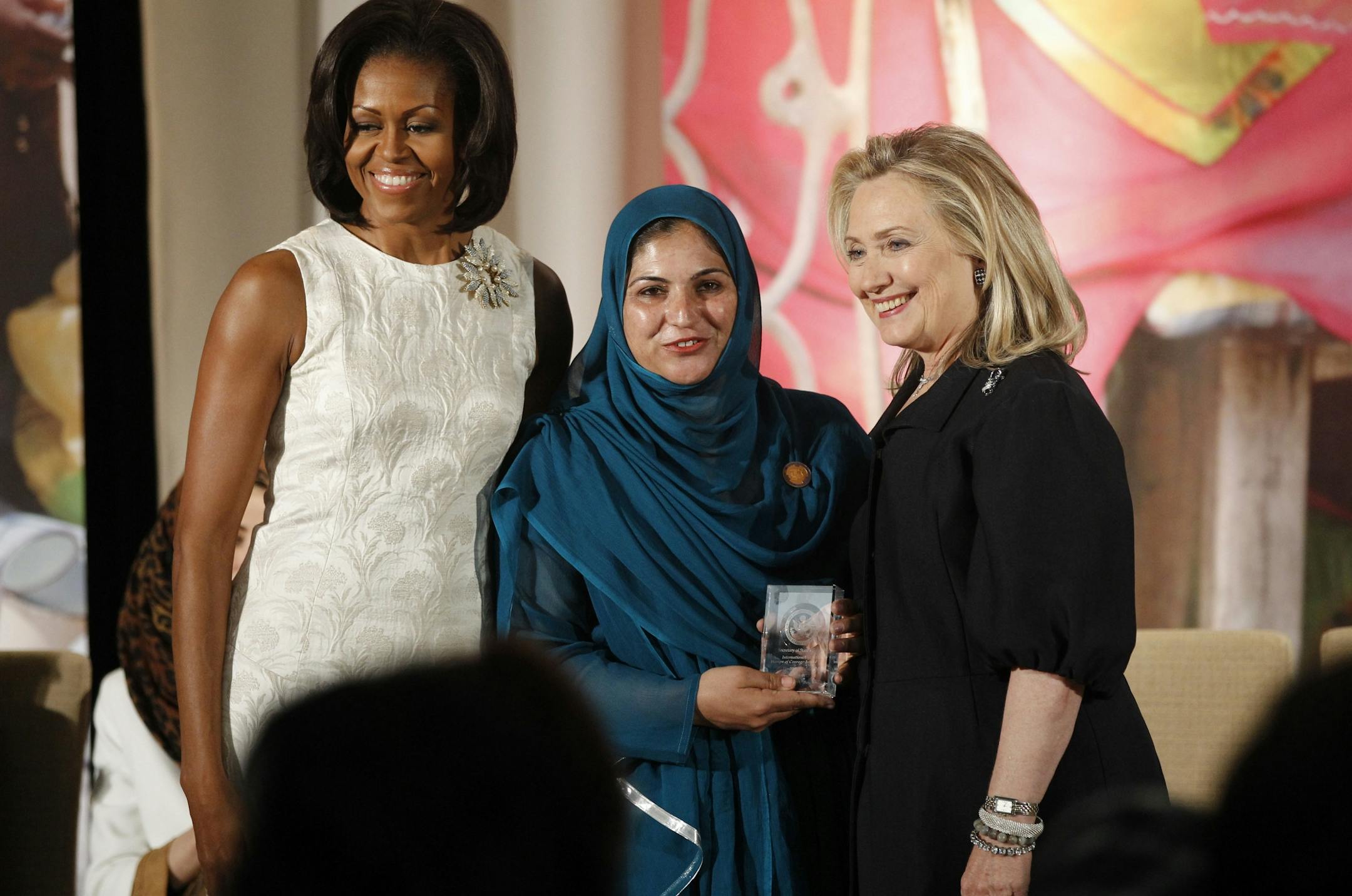Secretary of State Hillary Rodham Clinton and first lady Michelle Obama present the 2012 International Women of Courage Award to Shad Begum of Pakistan, who provided education, political training, and microcredit to Pakistani women, on the 101st Anniversary of International Women's Day, Thursday, March 8, 2012, at the State Department in Washington.