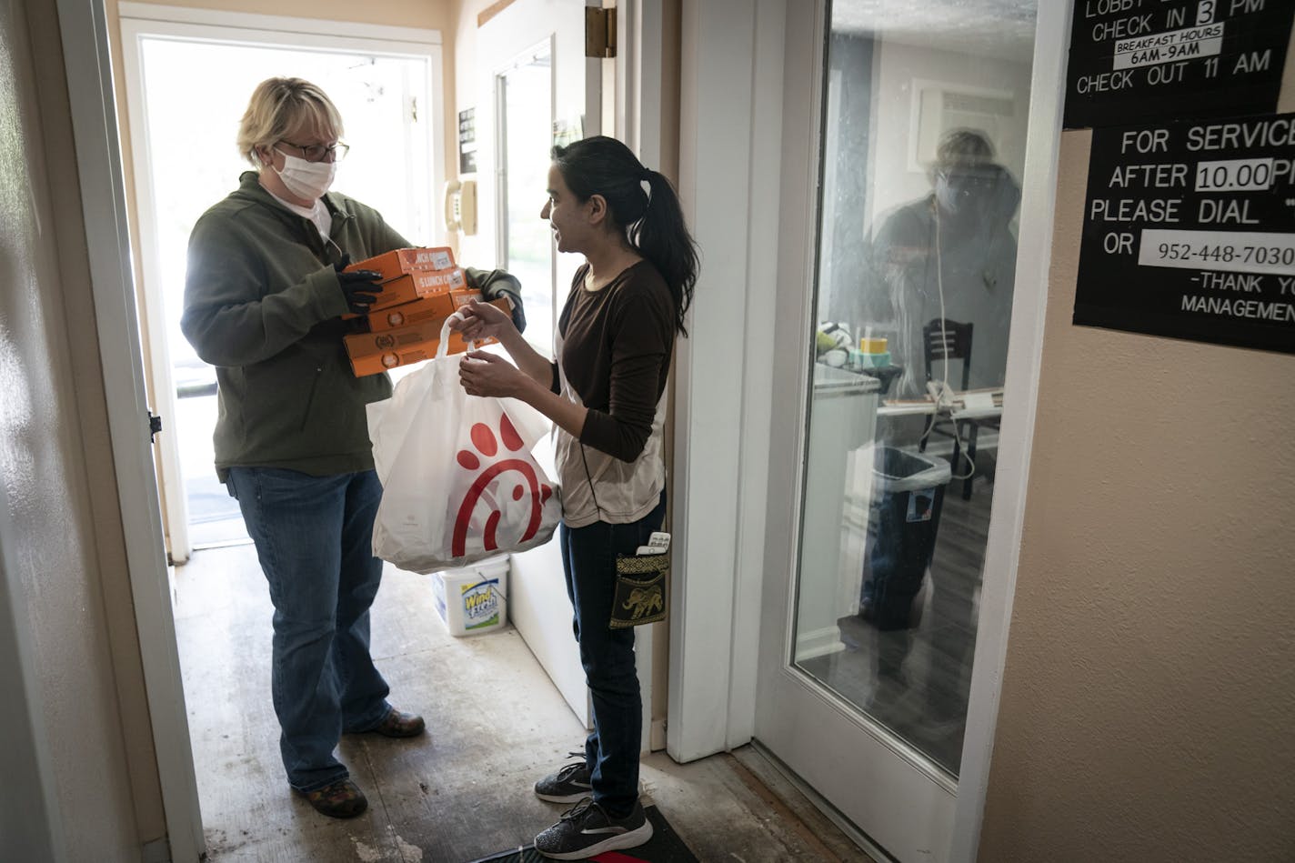 Chaska Super 8 general manager Sana Cheema, right, collected donated food from Chick-fil-A and Little Caesars from Martha Brannon of His House Foundation.