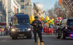 An armed police officer stands guard at the start of the Macy's Thanksgiving Day Parade, Thursday Nov. 26, 2015, in New York.