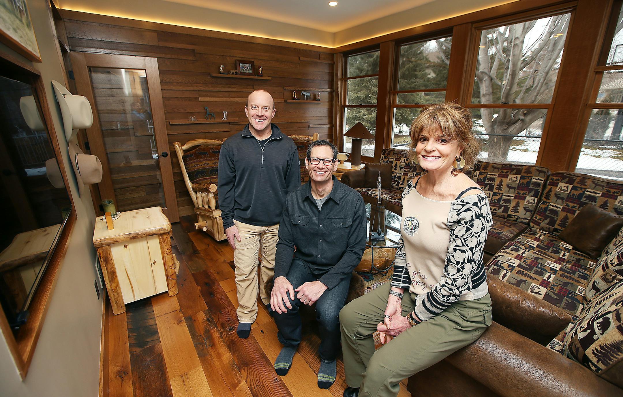 Carl Unger, left, and Nate Tollefson of Craft Design Build, with homeowner Caryn Schall in the rustic room that used to be her three-season porch.