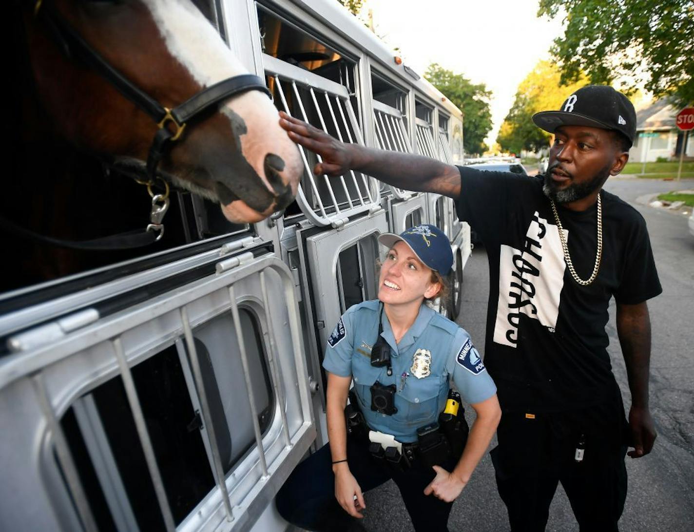 Damion Reid reached over officer Erin Grabosky, with the Minneapolis police mounted unit, during a National Night Out stop at the 4700 block of Bryant Avenue N.