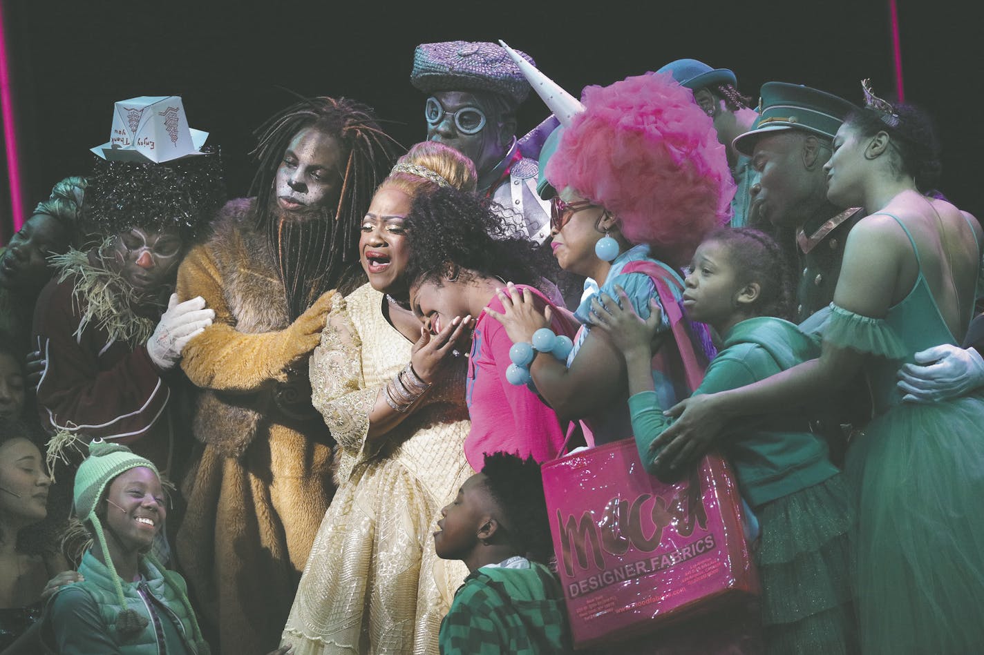 Jamecia Bennett, as Glinda, holds her daughter, Paris Bennett, starring as Dorothy, in the Children's Theatre production of "The Wiz."