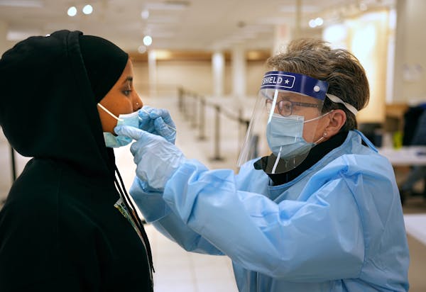 Naima Ahmed received one of the last COVID-19 tests administered by nurse Sue Clarke at the state’s St. Paul Midway testing site before it shut down