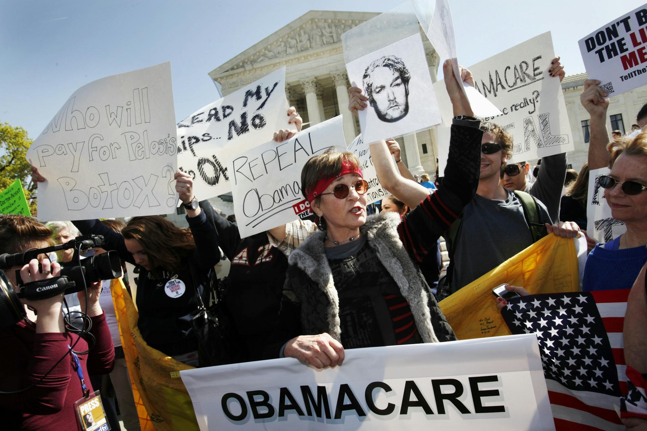 Protesters who identified themselves as being with the Tea Party Patriots, including Linda Dorr, of Laguna Beach, Calif., center, demonstrate against the health care law outside of the Supreme Court in Washington, Monday, March 26, 2012, as the court began hearing arguments on President Obama's health care legislation.
