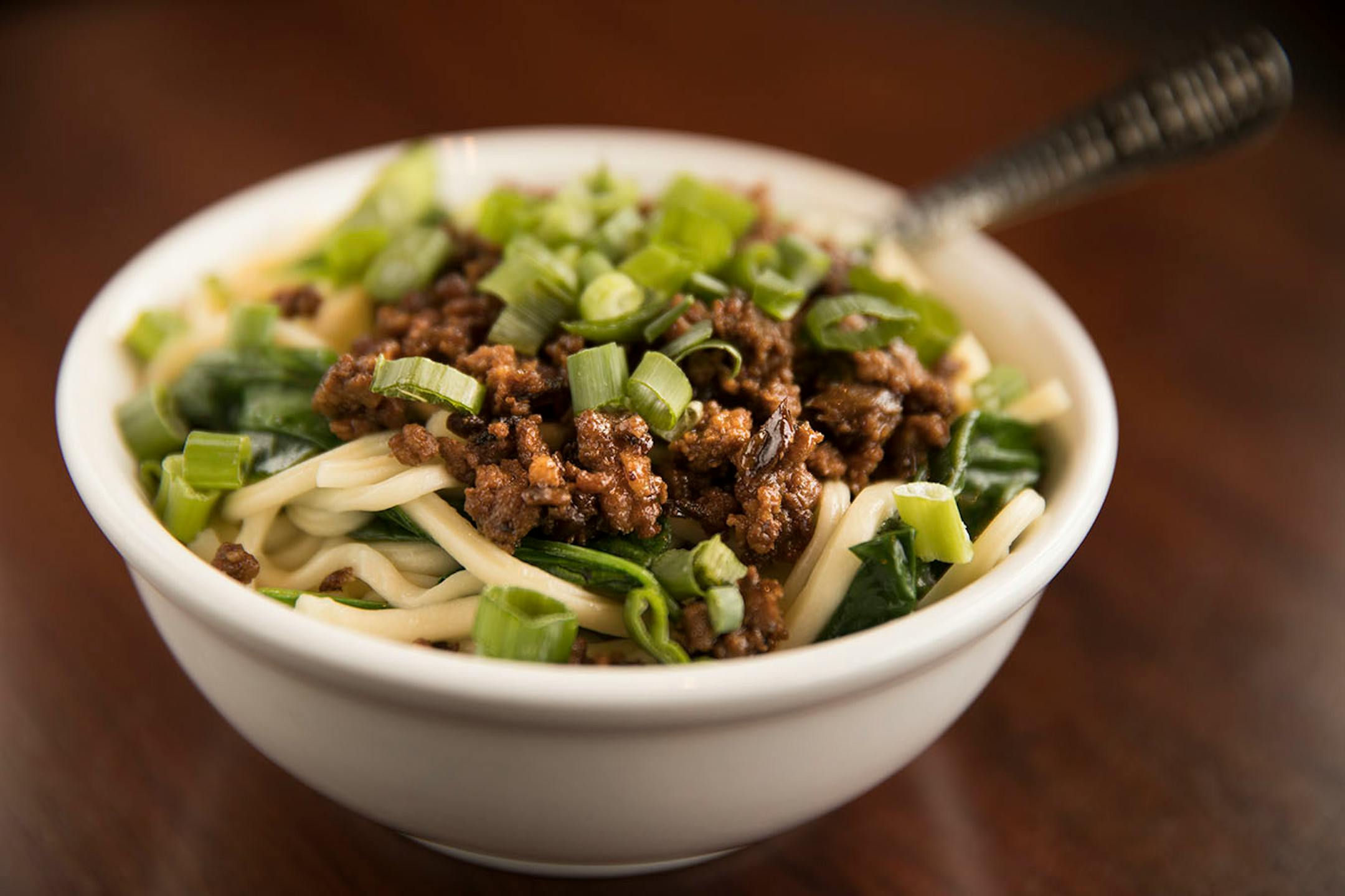 Dan dan noodles topped with spicy sesame sauce, green veggies and minced pork.