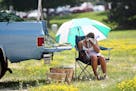 FILE - In this July 18, 2011 file photo, Tiffany Carrels, of Lake City, Minn. wipes the sweat from her face with a towel as she sells sweet corn at th