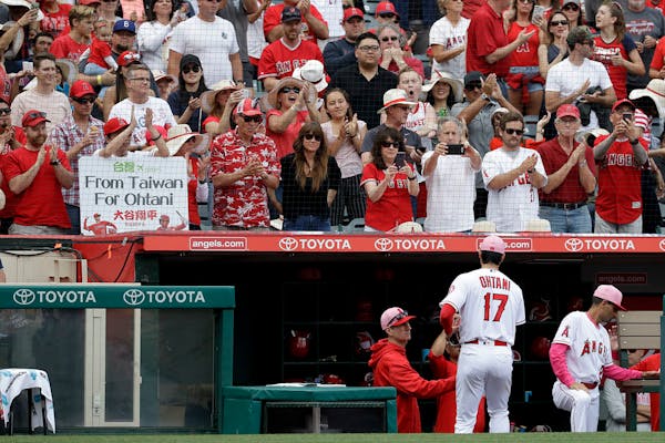 Fans clap as Los Angeles Angels starting pitcher Shohei Ohtani, of Japan, leaves the field during the seventh inning of a baseball game against the Mi
