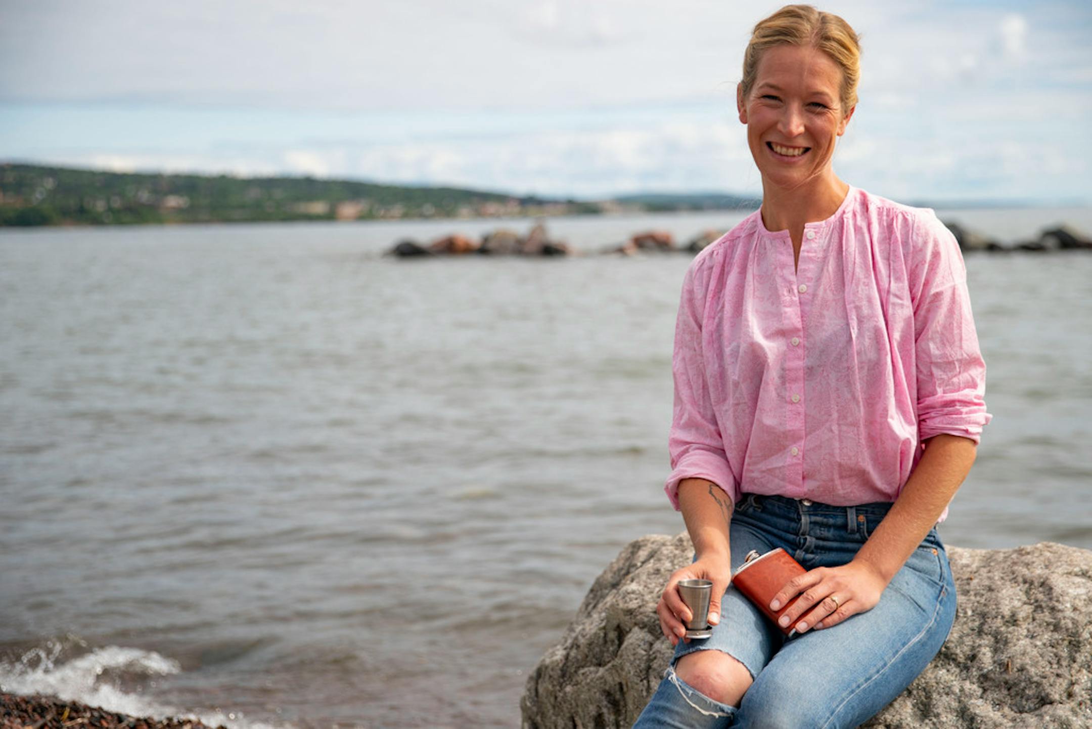 Emily Vikre posed with her travel flask and collapsible cup on the shore of Lake Superior in Duluth: "You don't need perfect bartending tools to make a really good cocktail."