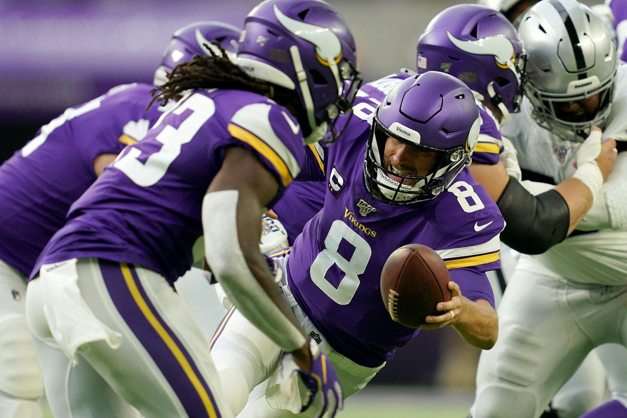 Minnesota Vikings quarterback Kirk Cousins (8) stumbled as he went to hand the ball off to Minnesota Vikings running back Dalvin Cook (33) in the first quarter.