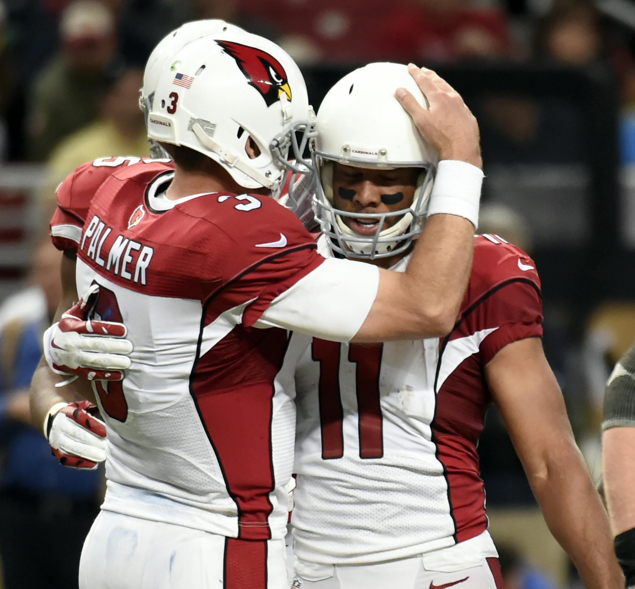 Arizona Cardinals wide receiver Larry Fitzgerald, right, is congratulated by quarterback Carson Palmer after catching a pass during the fourth quarter of an NFL football game against the St. Louis Ram on Sunday, Dec. 6, 2015, in St. Louis. With the reception, Fitzgerald has surpassed Andre Johnson as the youngest player to reach 1,000 career receptions in NFL history. (AP Photo/L.G. Patterson)