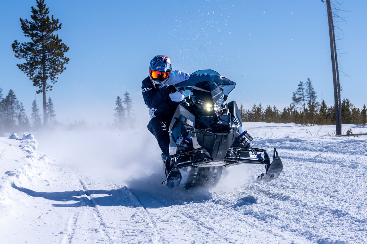 David Fischer, a professional snowmobile racer who has been around sleds all his life, says high-grade advances in suspension, steering and ergonomics make today's muscled-up snowmobiles safer to ride than sleds built 20 years ago that were just as fast. Here he accelerates on a designated snowmobile trail in northern Minnesota aboard a new Polaris 850 Patriot Boost Assault — a high-horsepower vehicle built with a factory-made, turbo-charged engine in a lightweight chasis. Photo provided by Broken Arrow Studios