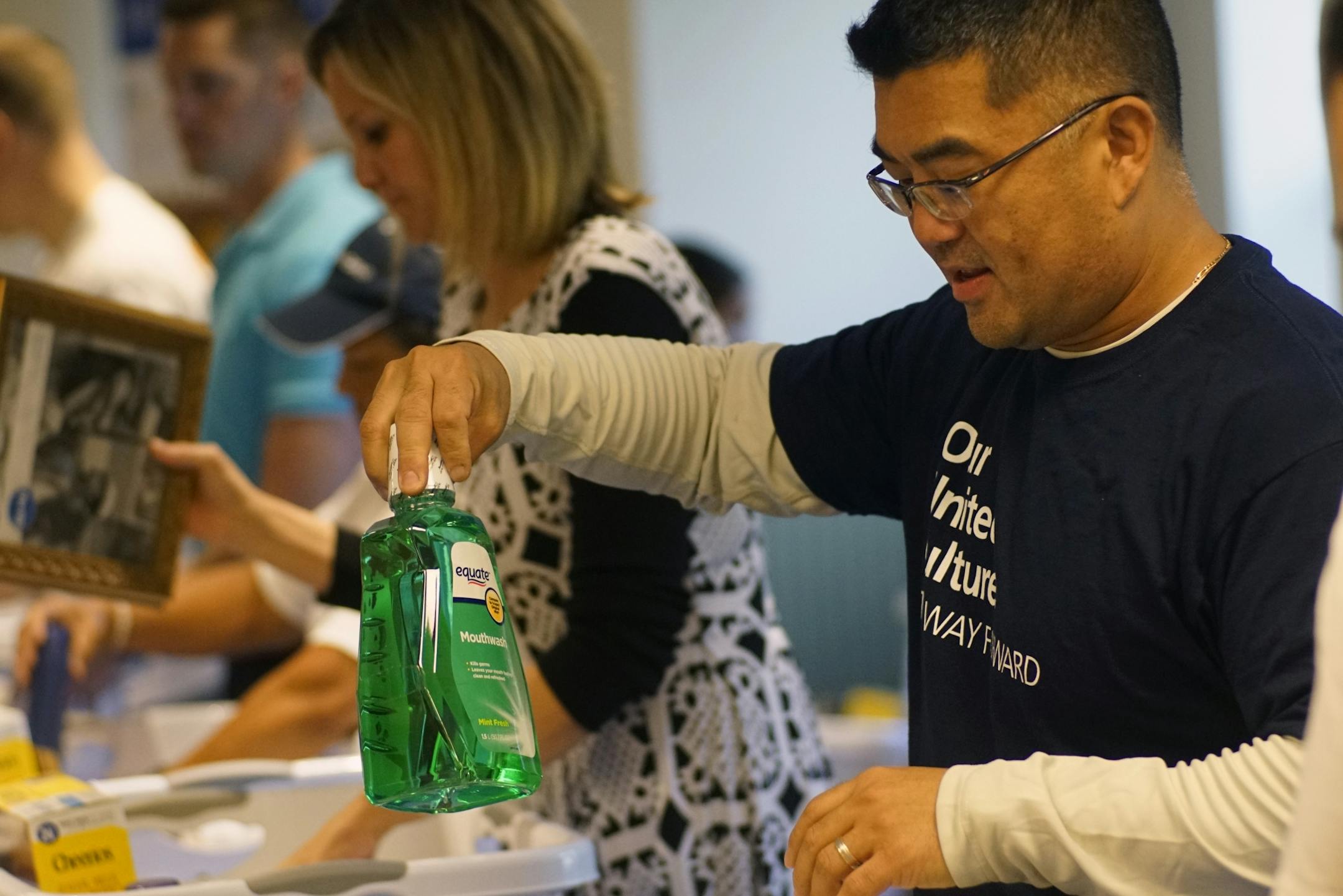Michael Yu, a veteran employed at United Health Group, packs some mouth wash for a welcome basket.