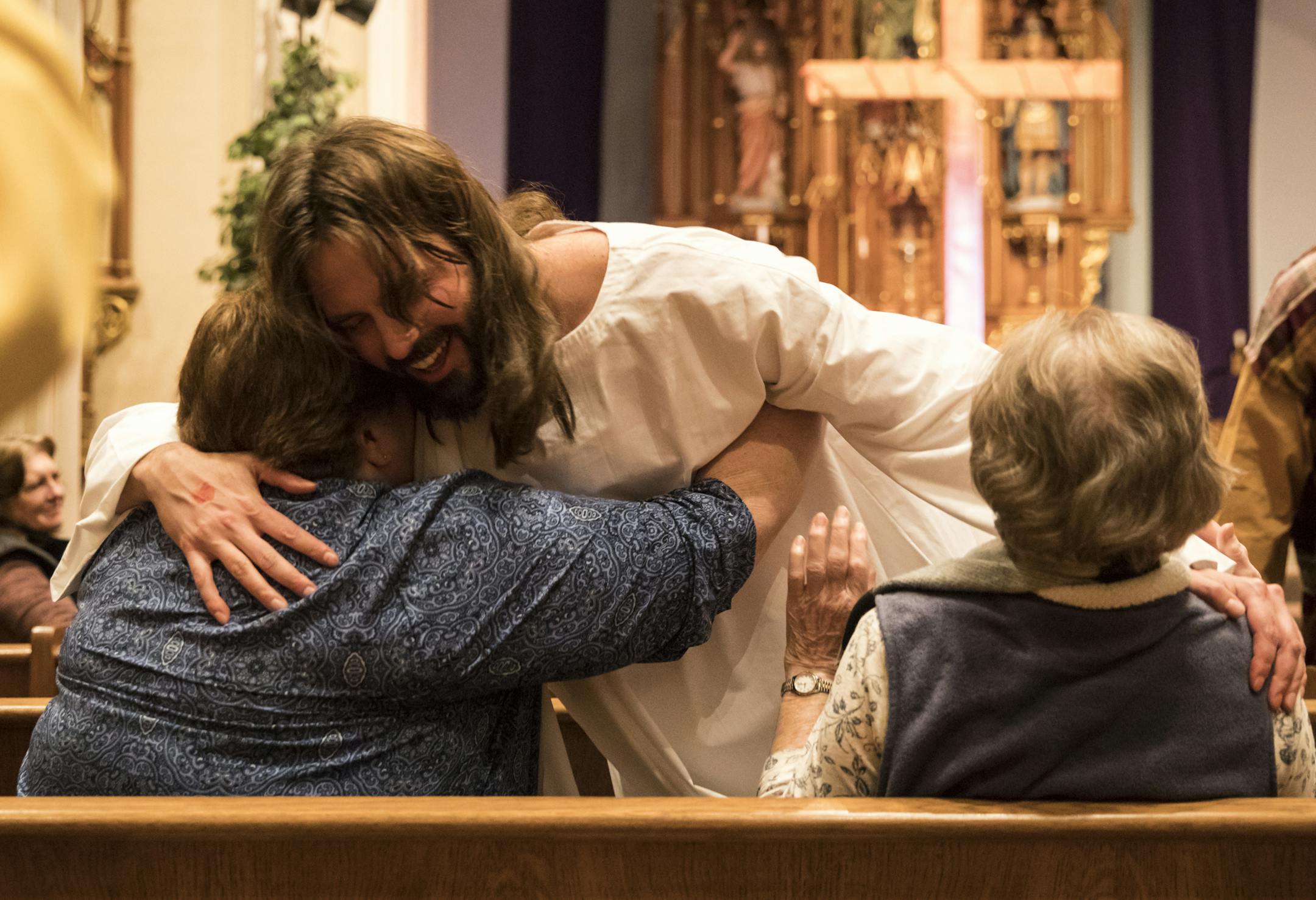 Jesus, played by Father Erik Lundgren, hugged audience members Vicki Storms and Dell Reed saying "He is risen" during a dress rehearsal for The Passion of Jesus in Music, Word and Light at Saint Mark's Church in Shakopee, Minn., on Wednesday, March 7, 2018. ] RENEE JONES SCHNEIDER • renee.jones@startribune.com