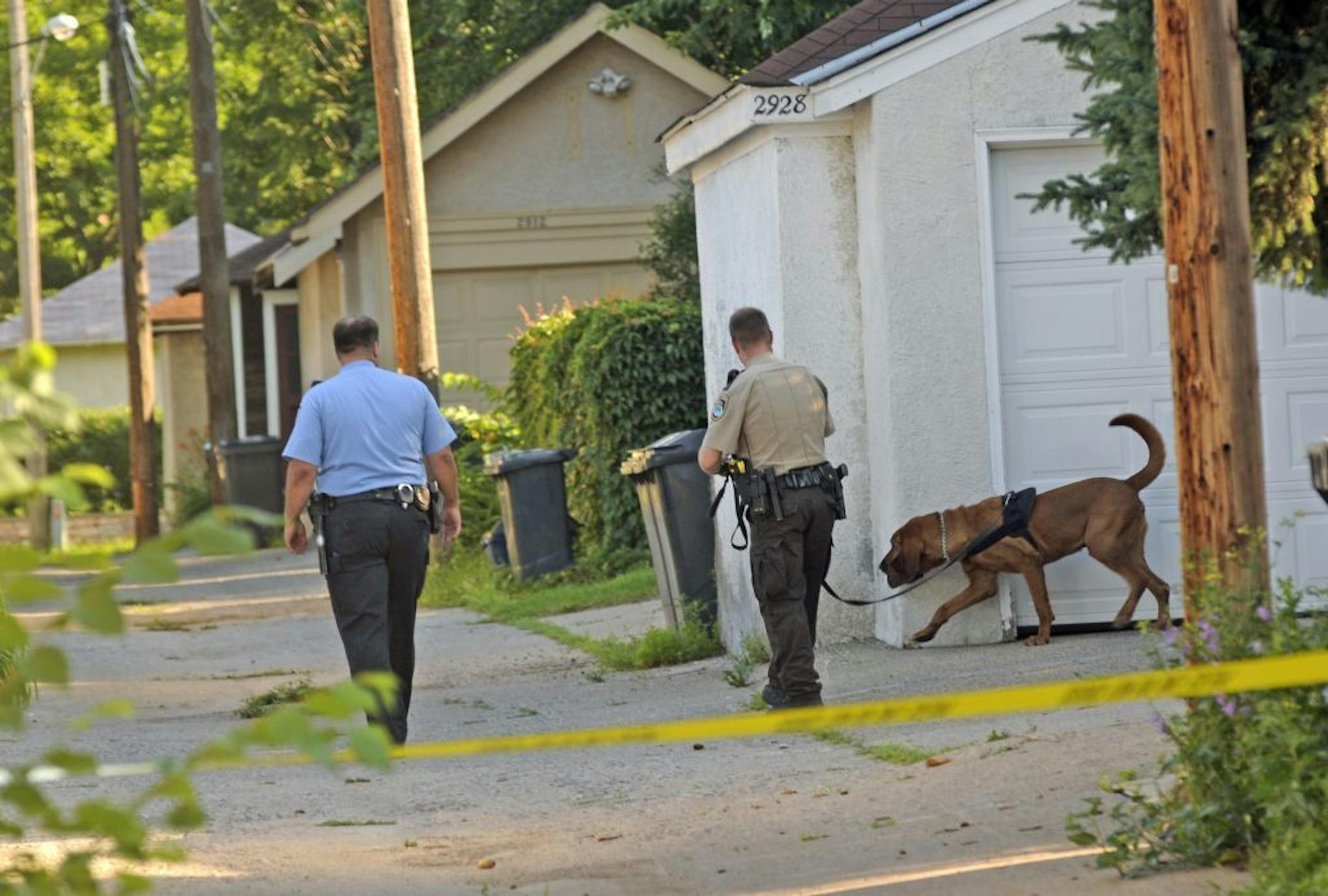 A Hennepin County Sheriff's deputy and a Minneapolis police officer searched the scene of a fatal shooting on 45th Ave S. in Minneapolis, Wednesday morning July 20, 2011.