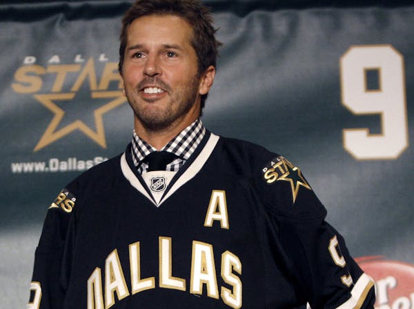 FILE - In this Sept. 23, 2011, file photo, NHL hockey player Mike Modano wears a Dallas Stars jersey during a news conference announcing his retiremen