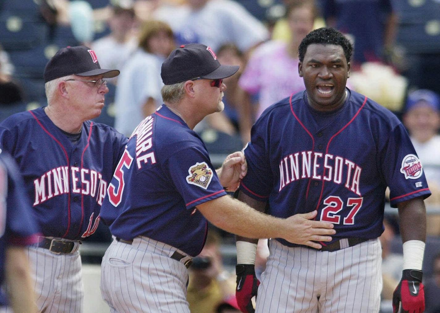 Minnesota Twins' David Ortiz, right, is moved toward the dugout by manager Tom Kelly, left, and third base coach Ron Gardenhire, center, after being ejected for arguing strike calls with plate umpire Paul Schrieber during the fifth inning against the Kansas City Royals, Sunday, Aug. 26, 2001, in Kansas City, Mo. The Twins won 7-2. (AP Photo/Ed Zurga) ORG XMIT: KXS104