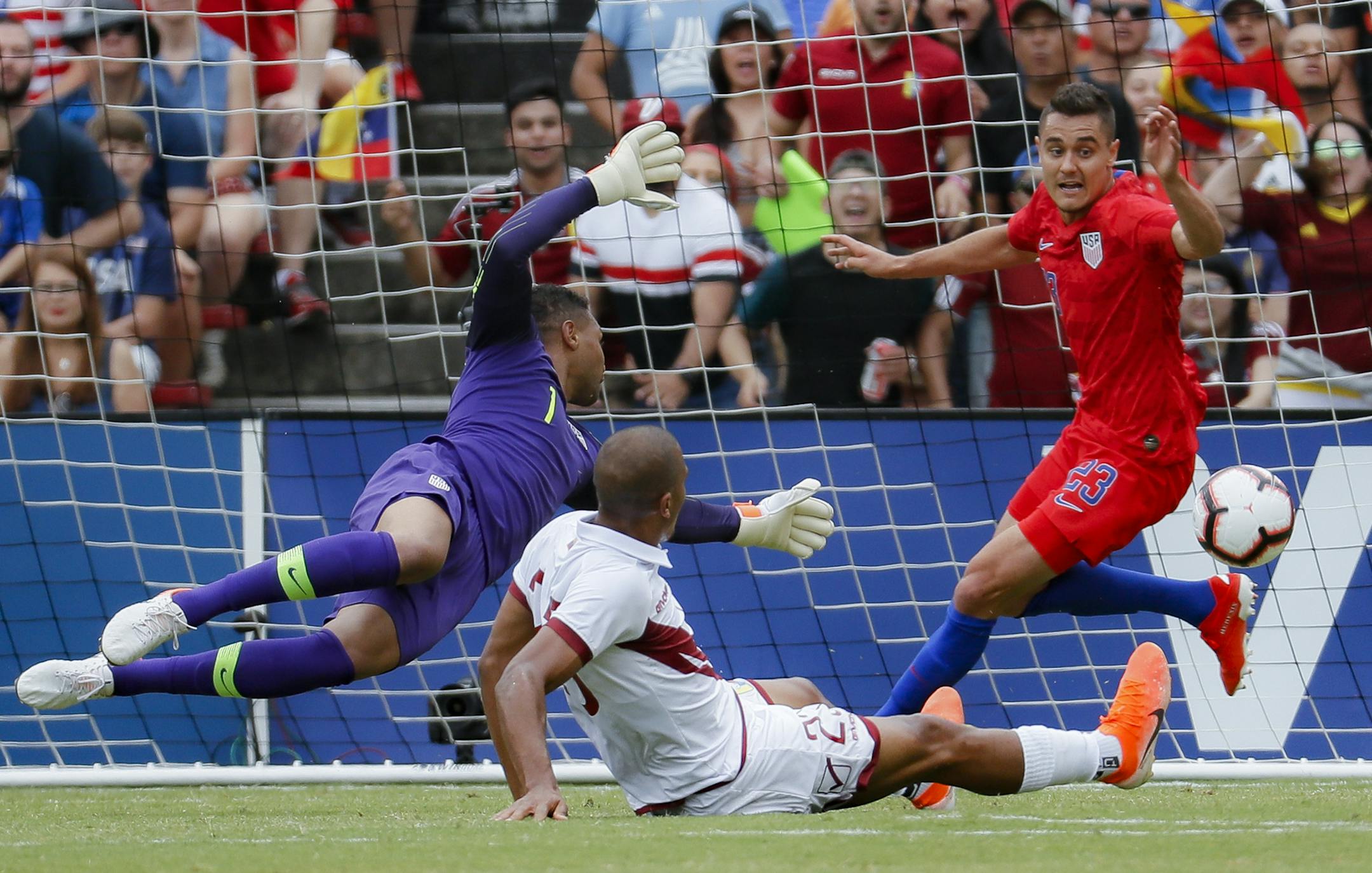 Venezuela forward Jose Salomon Rondon, center, scores against United States goalkeeper Zack Steffen (1) and defender Aaron Long (23) during the first half of an international friendly soccer match, Sunday, June 9, 2019, in Cincinnati. (AP Photo/John Minchillo)