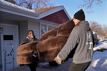 Two Men and a Truck movers Arty Nelson, left, and Jared (DOESN'T WANT LAST NAME USED) carry a couch to the truck Wednesday, March 29, 2023 in Shorevie