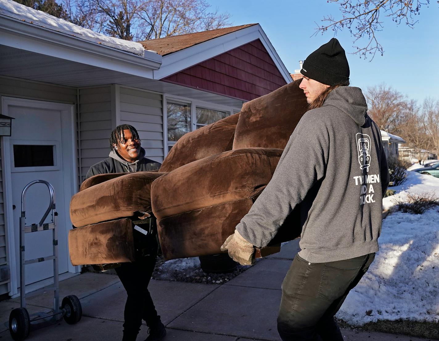 Two Men and a Truck movers Arty Nelson, left, and Jared (DOESN'T WANT LAST NAME USED) carry a couch to the truck Wednesday, March 29, 2023 in Shoreview, Minn. ]