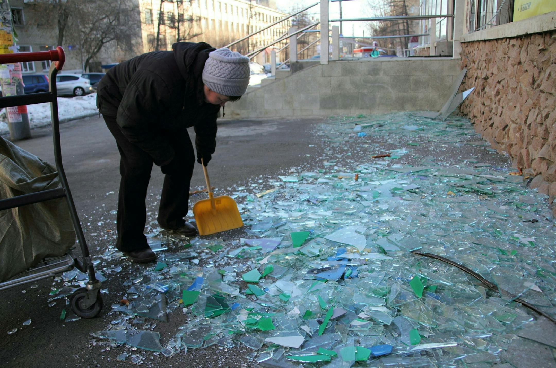 A worker sweeps up shattered glass from a store's broken windows in Chelyabinsk, Russia, February 15, 2013. A meteor that scientists estimate weighed 10 tons streaked at supersonic speed and exploded over Russia's Ural Mountains on Friday, setting off blasts that shattered glass and brought down walls, injuring hundreds.