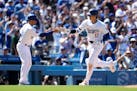 Los Angeles Dodgers designated hitter Shohei Ohtani celebrates with third base coach Dino Ebel, left, after hitting a home run during the eighth innin