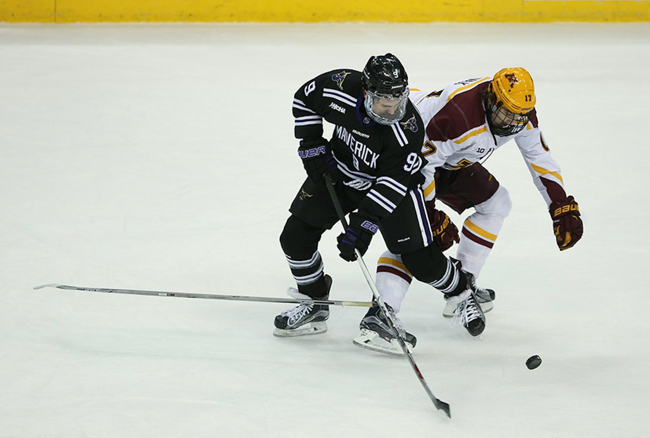 Mavericks forward Bryce Gervais (9) tried to maintain control of the puck while tangling with Gophers forward Tommy Novak (17) in the first period Sunday afternoon.