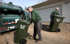 KYNDELL HARKNESS &#xef; kharkness@startribune.com Jim Berquist wheeled a trash can toward the back of the garbage truck while his son Mike put one bac