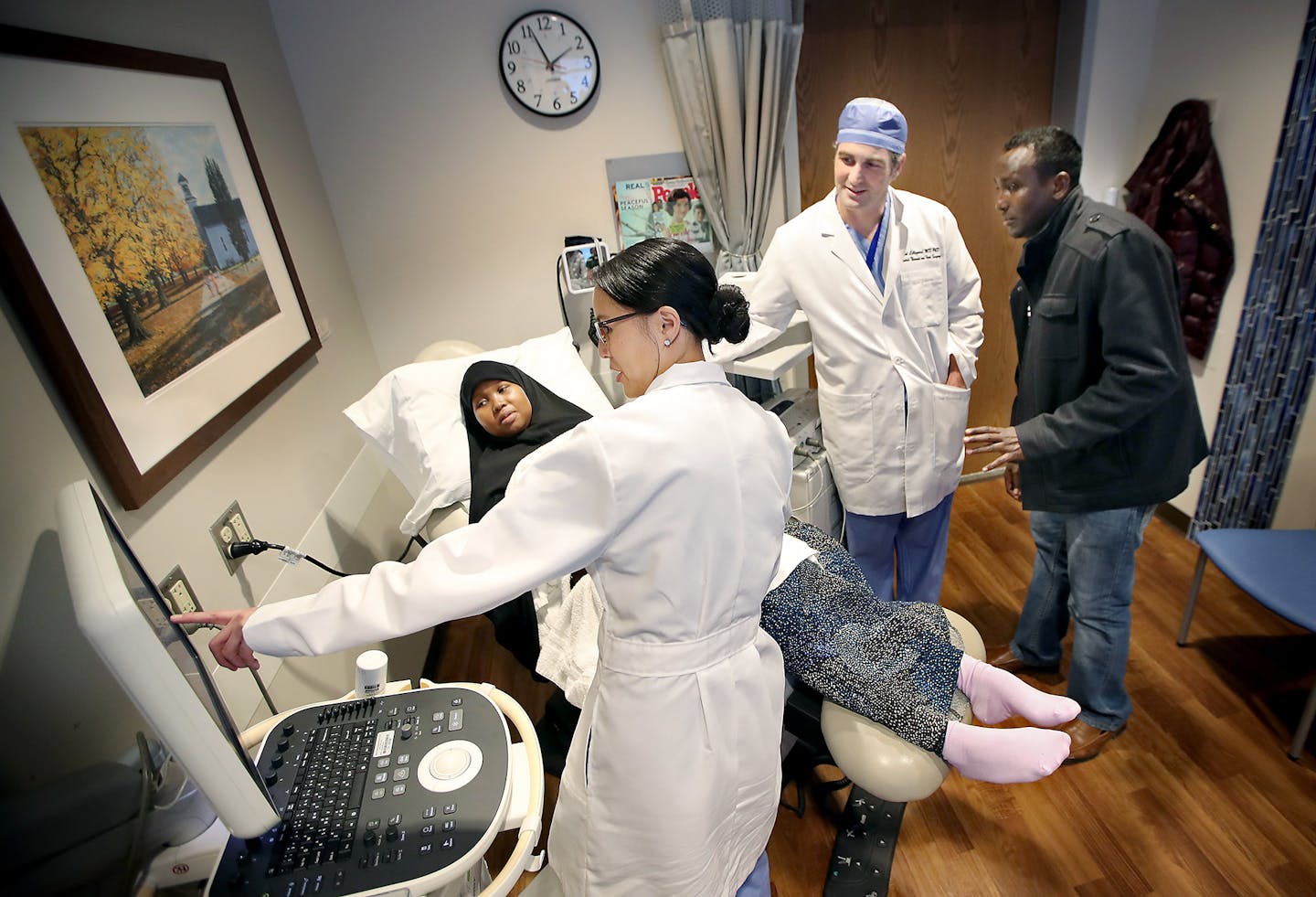 Dr. Marijo Aguilera, left, and Dr. Joseph Lillegard, right, performed an ultrasound on Suaado Salah as her husband. Tahlil Wehlie, looked on at The Mother Baby Center in Minneapolis. Surgeons at Children's/Abbott are performing prebirth surgeries on fetuses to treat spina bifida, a common birth defect cause of cognitive and physical disabilities. Joining about a dozen other hospitals in the U.S., the doctors are entering a field full of technical and ethical challenges.