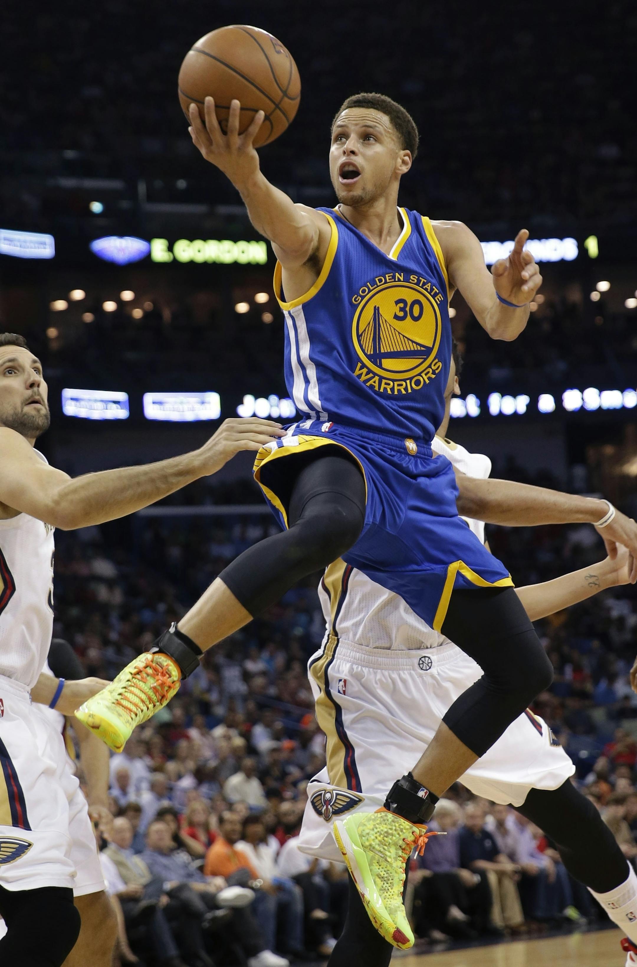 Golden State Warriors guard Stephen Curry (30) drives to the basket in front of New Orleans Pelicans forward Ryan Anderson in the first half of an NBA basketball game in New Orleans, Tuesday, April 7, 2015. (AP Photo/Gerald Herbert) ORG XMIT: LAGH101
