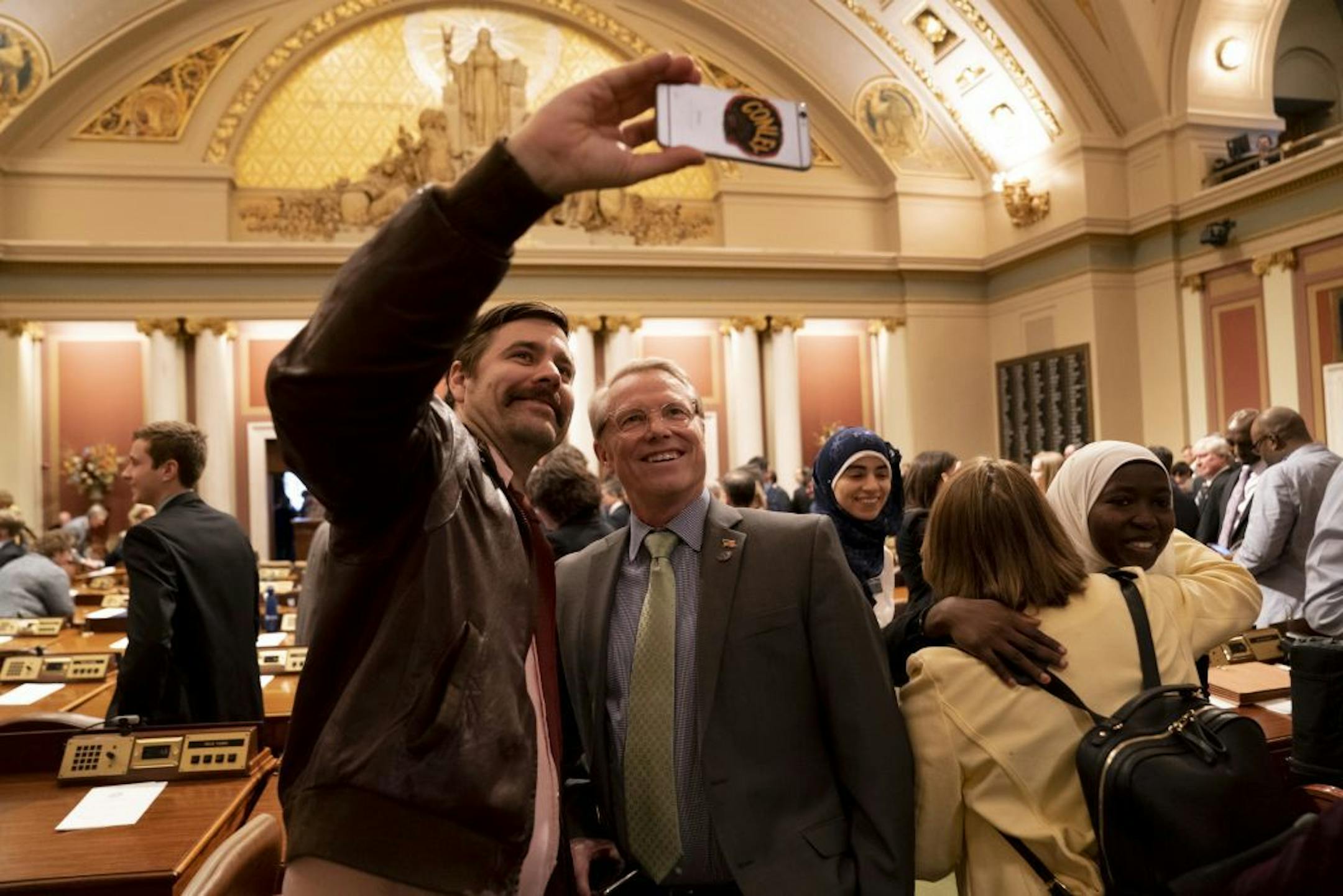 Rep. Raymond Dehn, right, took a selfie with his guest Matt Barthelemy before the State of the State Address at the State Capitol in St. Paul, Minn., on Wednesday, April 3, 2019.
