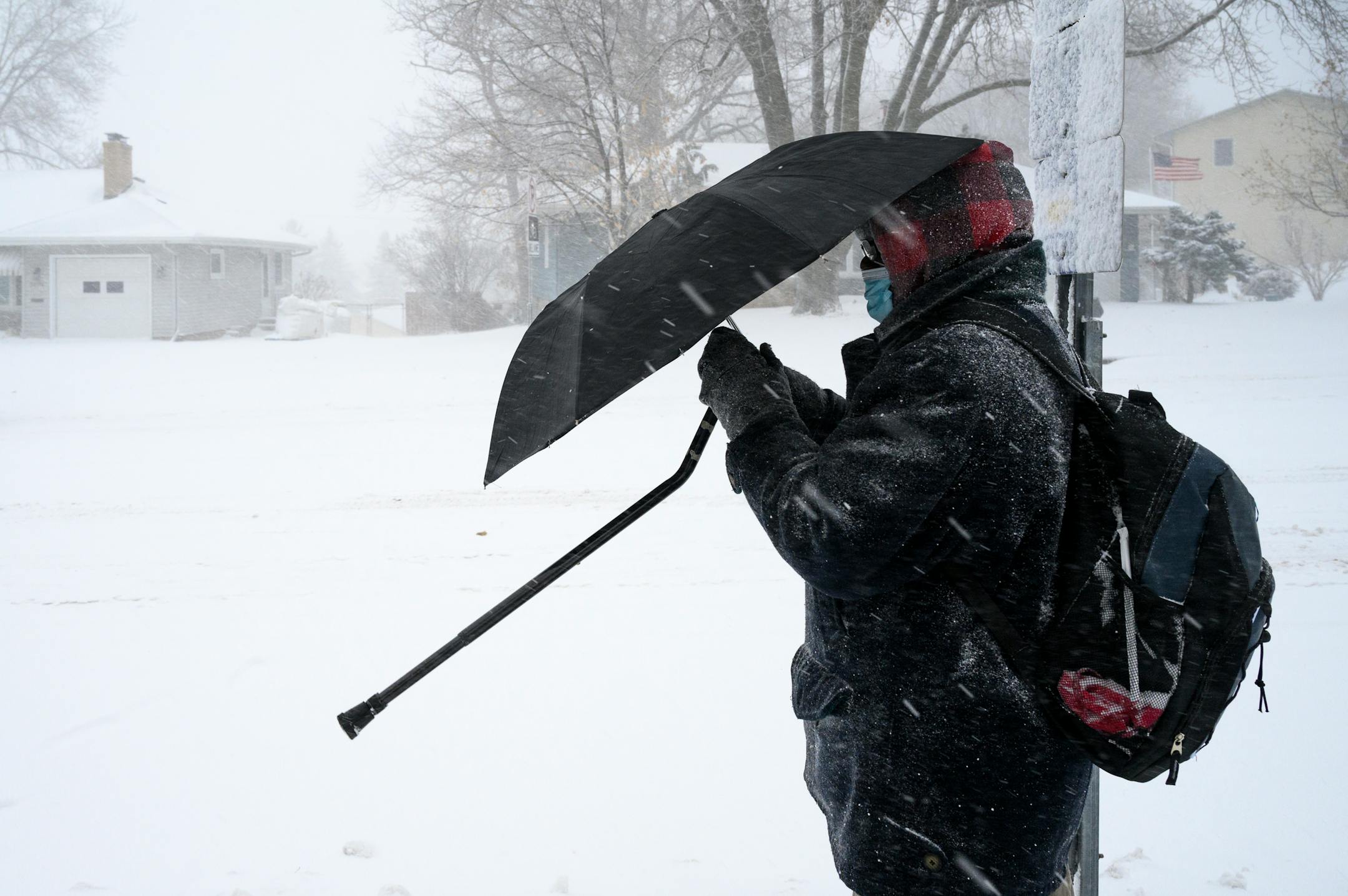 A man, who didn't wish to be identified, used an umbrella to keep the wind-whipped snow out of his face while waiting for a bus along France Avenue North in Robbinsdale Wednesday afternoon.