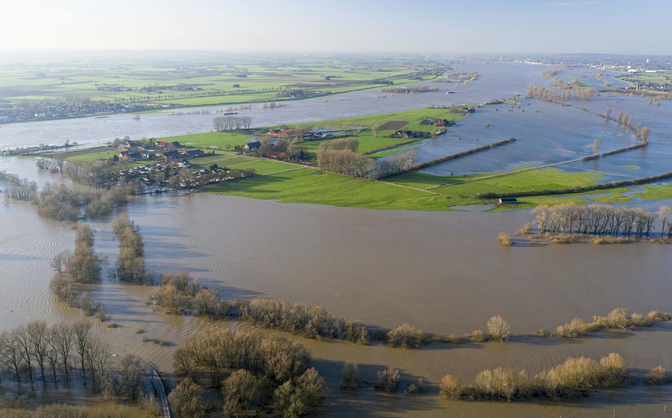FILE - In this Jan. 8, 2018 file photo taken with a drone shows the flooded village of Rees at river Rhine, Monday, Jan. 8, 2018. Scientists say millions more people around the world are threatened by river floods in coming decades due to climate change. Researchers in Germany say greater flood defenses are particularly needed in the United States, parts of India and Africa, Indonesia and Central Europe. (Arnulf Stoffel/dpa via AP)