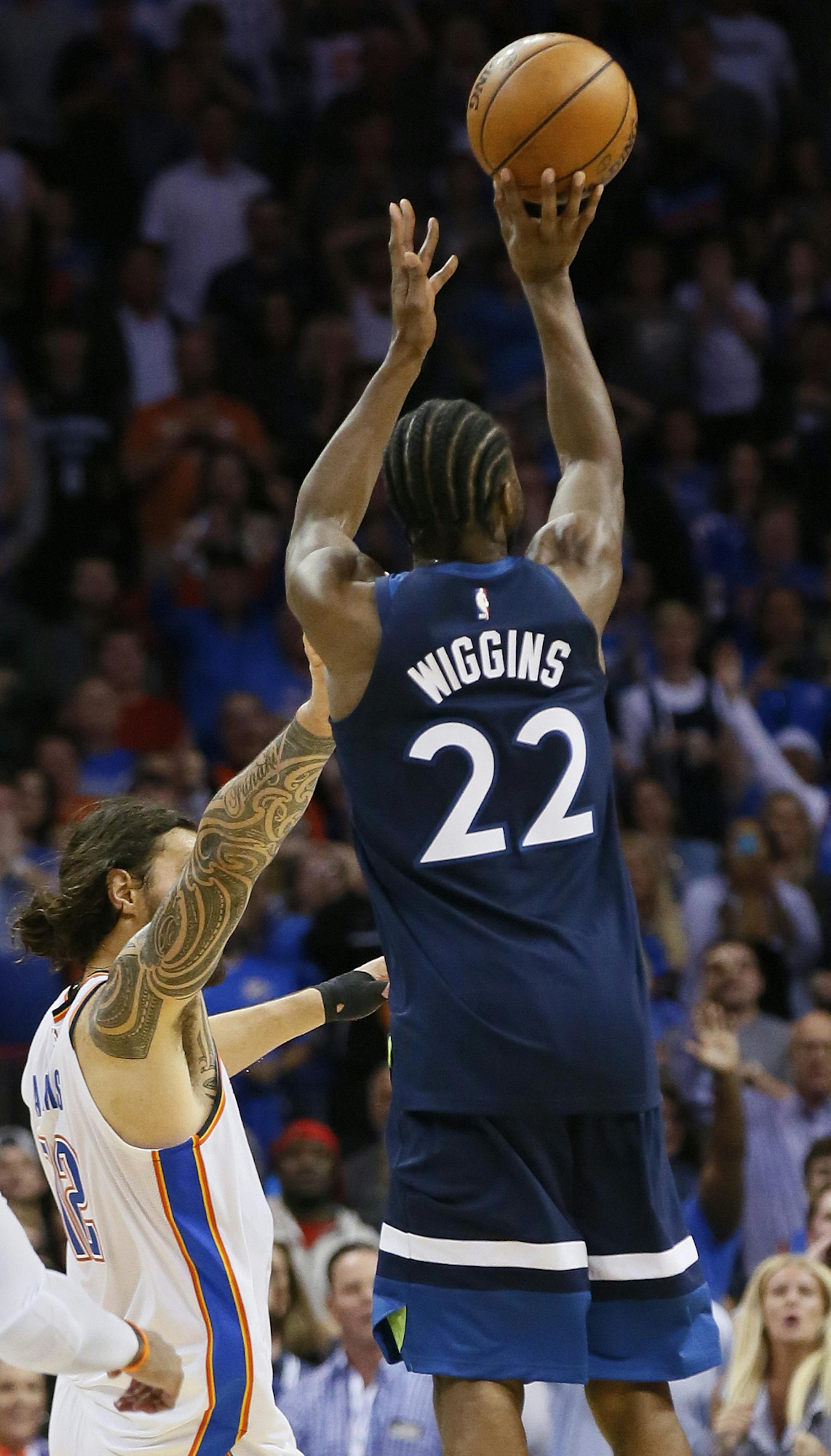 Minnesota Timberwolves guard Andrew Wiggins (22) shoots the game winning shot between Oklahoma City Thunder center Steven Adams (12) and guard Alex Abrines (8) in the fourth quarter of an NBA basketball game in Oklahoma City, Sunday, Oct. 22, 2017. Minnesota won 115-113. (AP Photo/Sue Ogrocki)
