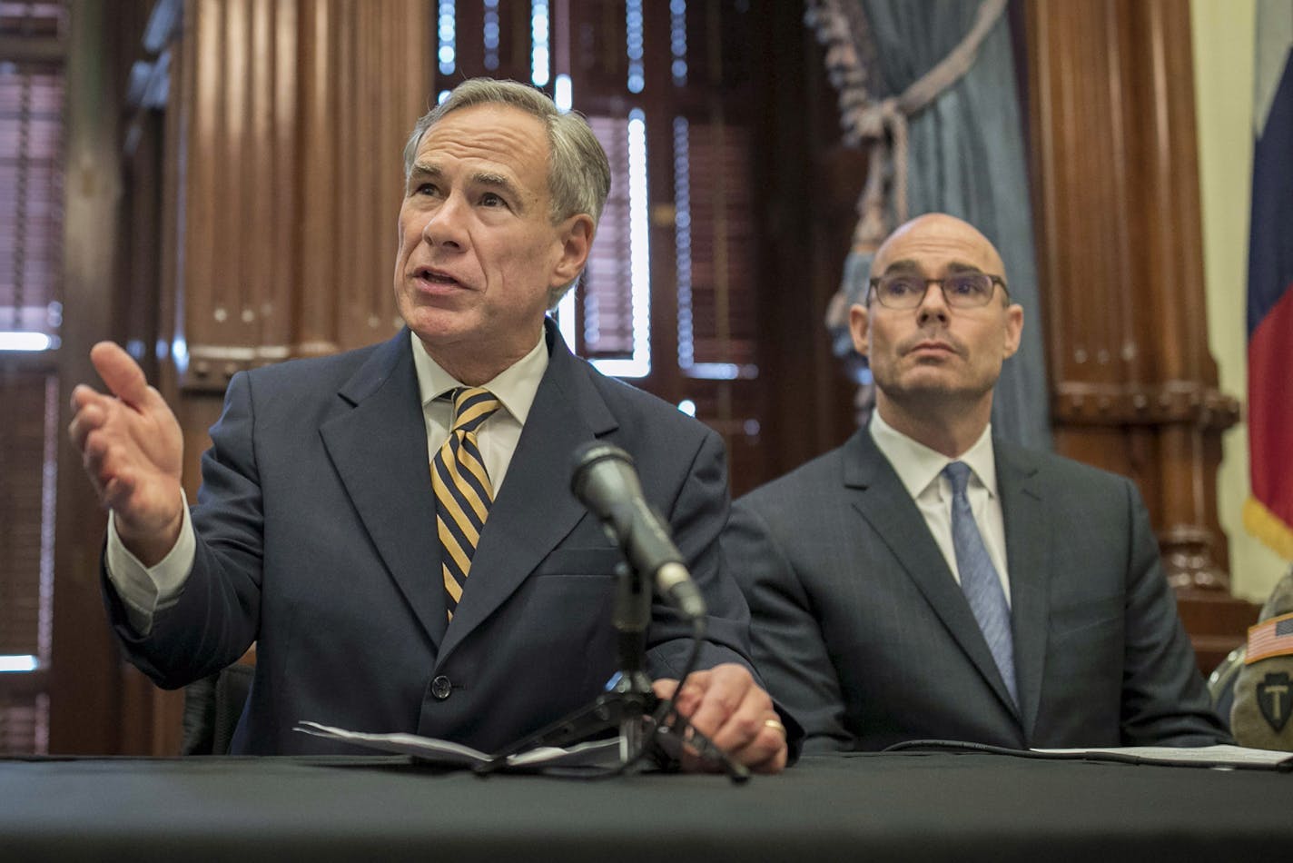 FILE - In this June 21, 2019 file photo, Gov. Greg Abbott, left, speaks at a news conference at the Capitol, in Austin, Texas. Abbott says the state will reject the re-settlement of new refugees, becoming the first state known to do so under a recent Trump administration order. In a letter released Friday, Jan, 10, 2020, Abbott wrote that Texas "has been left by Congress to deal with disproportionate migration issues resulting from a broken federal immigration system." He added that Texas, which