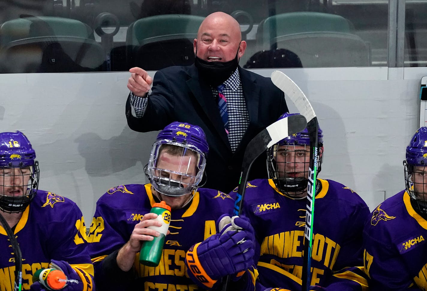 Minnesota State head coach Mike Hastings, back, directs his team against Minnesota in the second period of an NCAA College Hockey Regional Final, Sunday, March 28, 2021, in Loveland, Colo. (AP Photo/David Zalubowski)