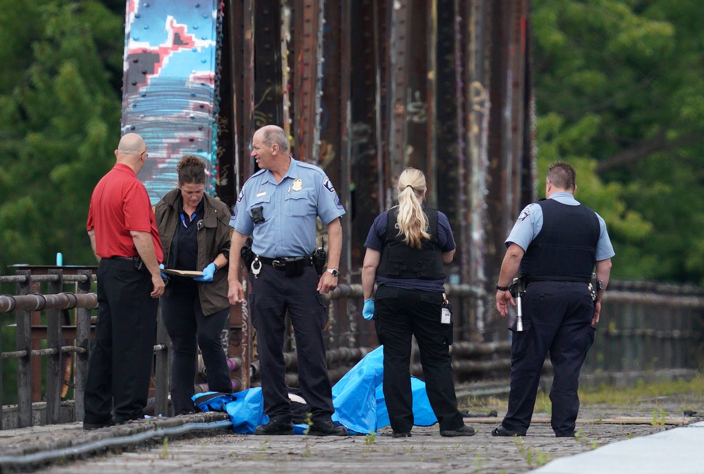 A man's body was covered with a blue tarp as police investigated the scene where he was found dead on Aug. 13, 2019 on the railway tracks near the intersection of 16th Avenue and NE Marshall Street.