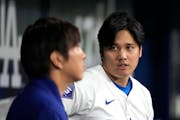 Two versions exist of a saga involving betting, bookies, lies and theft, with Los Angeles Dodgers star Shohei Ohtani, right, and his interpreter Ippei