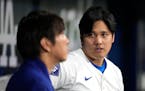Two versions exist of a saga involving betting, bookies, lies and theft, with Los Angeles Dodgers star Shohei Ohtani, right, and his interpreter Ippei