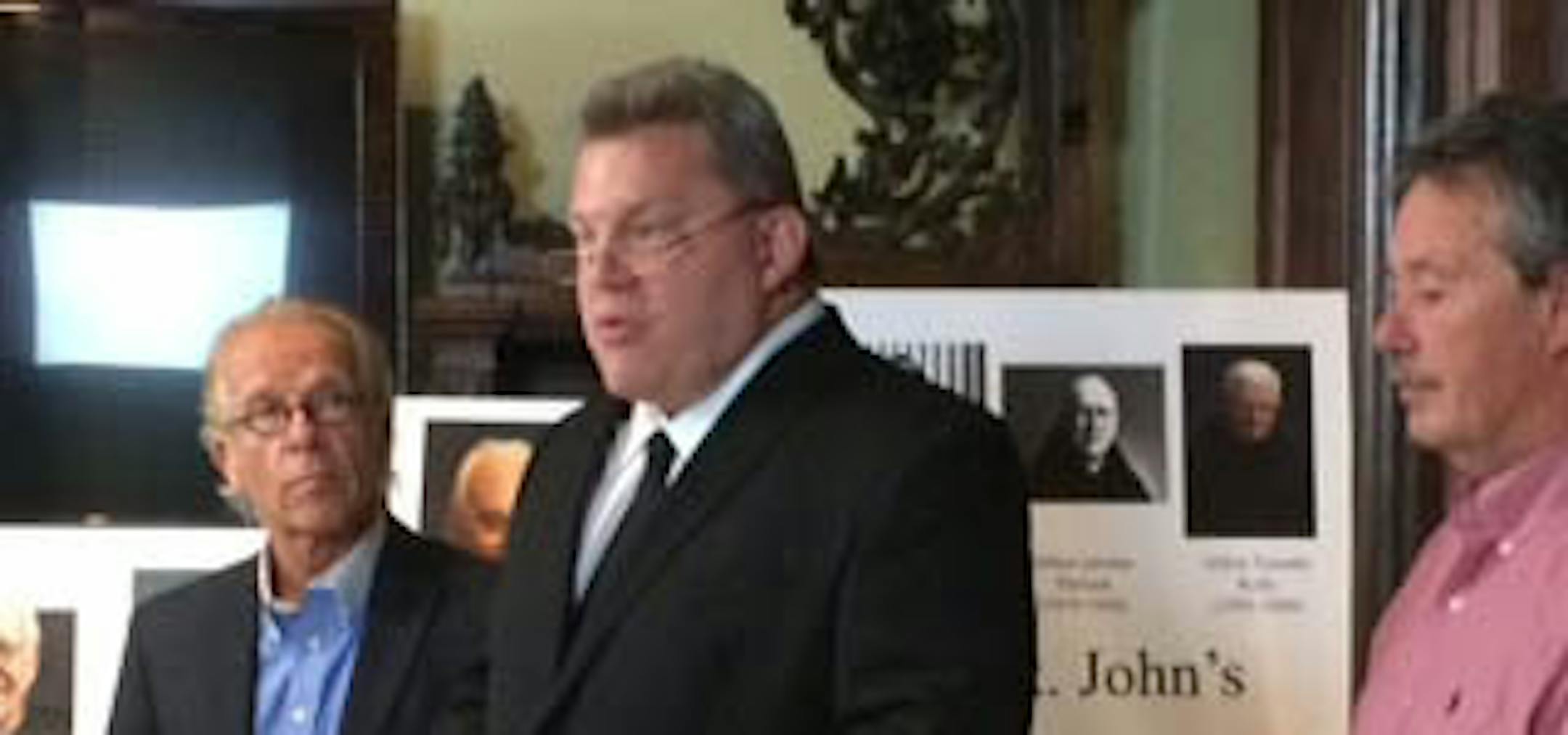 Patrick Wall (center), former monk at St. John’s Abbey who is now an investigator for Jeff Anderson & Associates, shared information about accused abusive monks at a news conference Monday. At left is attorney Jeff Anderson, while at right is Lloyd Van Vleet, who reached a settlement with St. John’s over his abuse.